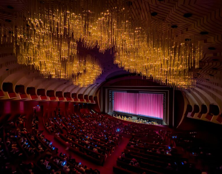 A grand opera house interior showcasing a captivating chandelier and stage with an audience.