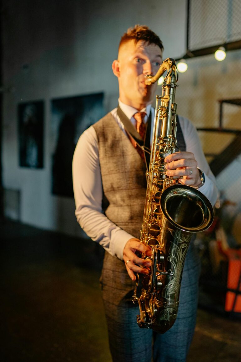 A well-dressed saxophonist plays passionately in a modern indoor setting.